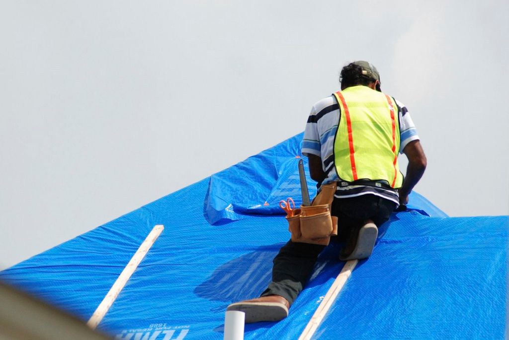 Roofer working on top of a house